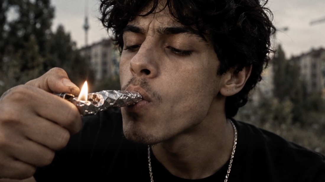 A young man smoking from foil